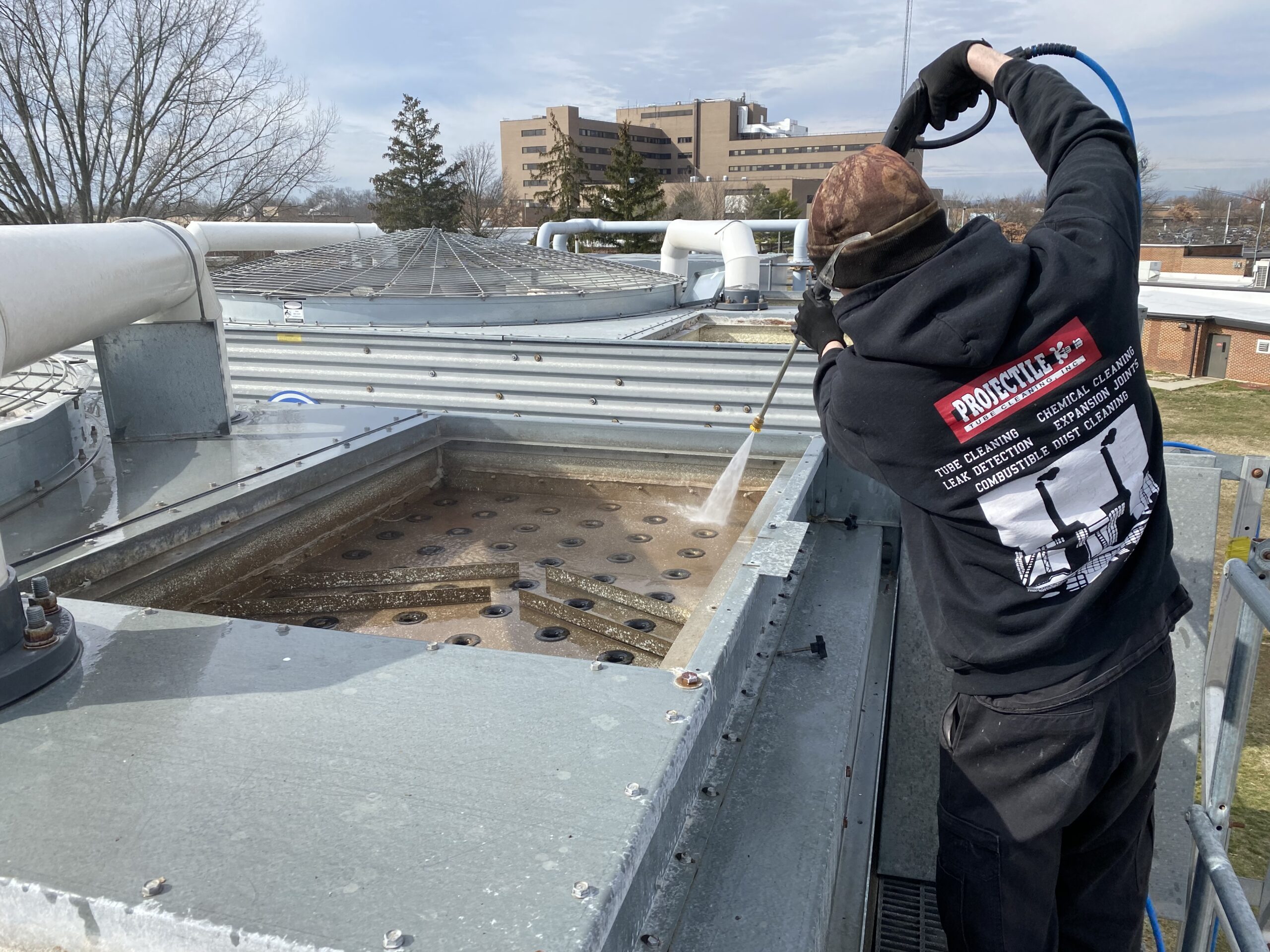 Worker cleaning cooling tower as part of Projectile’s cooling tower cleaning services